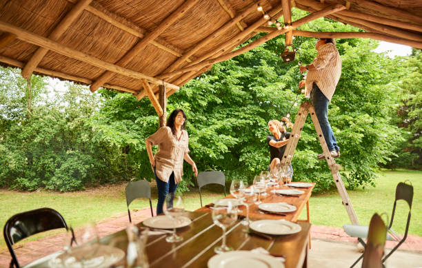 Shot of a man and woman hanging lights in a party patio