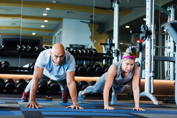 istock Hispanic couple working out at the gym, planks 1270692806