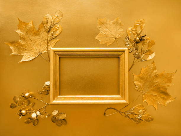 istock The concept of autumn. Maple leaf, rosehip, painted with gold paint and a text frame on a background of gold paper. 1270692996