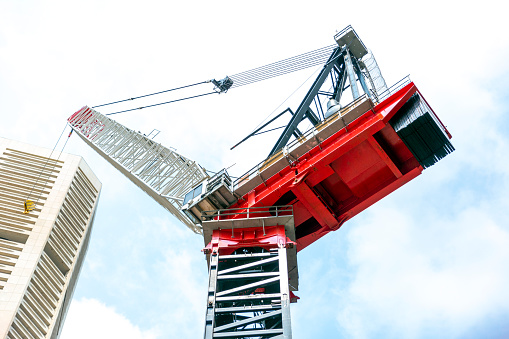 Tower crane at construction site, low angle view, sky background with copy space, full frame horizontal composition