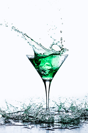 Green cocktail splash; martini glass