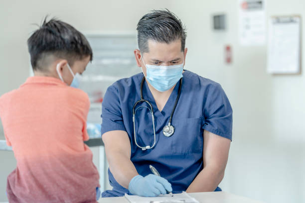 istock 8 year old boy at doctors appointment wearing a mask 1270697879