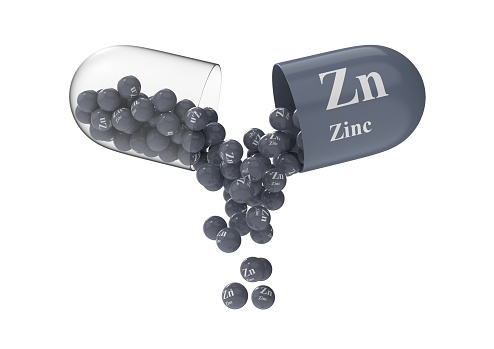 Cápsula abierta con zinc de la que se vierte la composición vitamínico photo