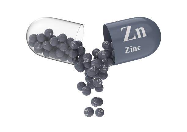 capsula aperta con zinco da cui versa la composizione vitaminica - zinc foto e immagini stock