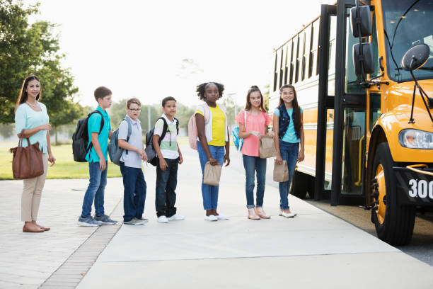istock Middle school students, teacher boarding a bus 1270704030