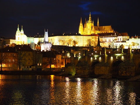 Karluv Most. Czech RepublicVltava river, Charles Bridge and Old Town Bridge Tower in Prague at night against a blue sky.