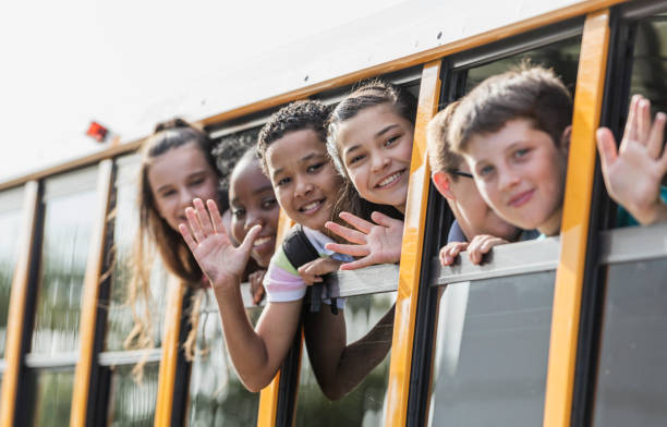 istock Students riding school bus, waving out window 1270704714