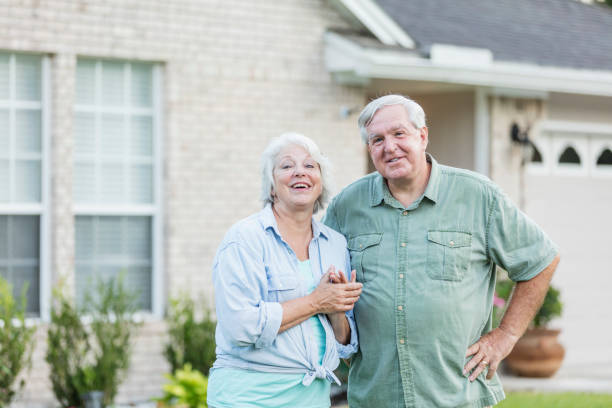 Senior couple standing in front of home