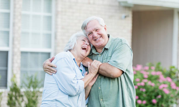 istock Senior couple standing in front of home, hugging 1270706073