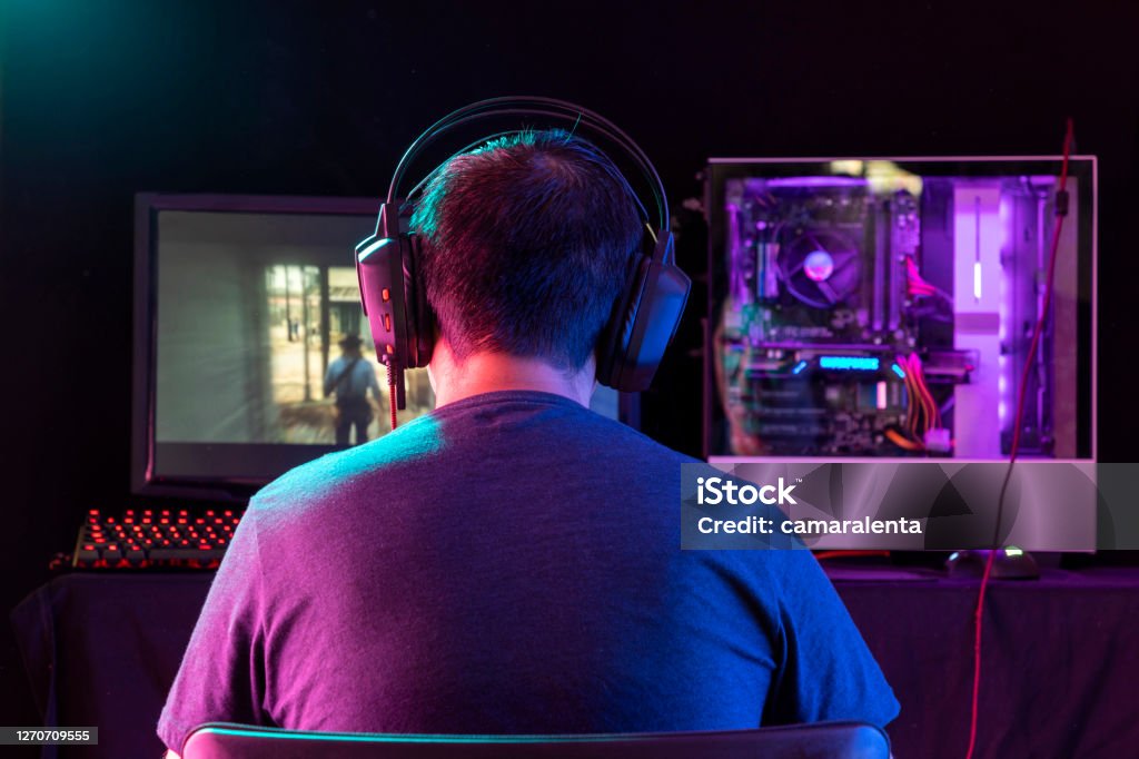 Portrait of the Young  Pro Gamer Playing in Online Video Game. Portrait of the Young  Pro Gamer Playing in Online Video Game. Neon and magenta Colored Room. e-Sport Cyber Games Internet Championship. Motion sweep in image. Home Video Camera Stock Photo