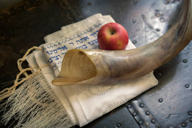 Shofar, Jewish prayer shawl (TALIT) and apple. Yom Kippur, Rosh Hashanah Close up of shofar ,Hebrew prayer book  and apple on a table- symbols for kosher symbol stock pictures, royalty-free photos & images