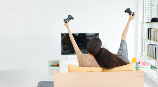 istock Two young women playing video games at home. 1270714409