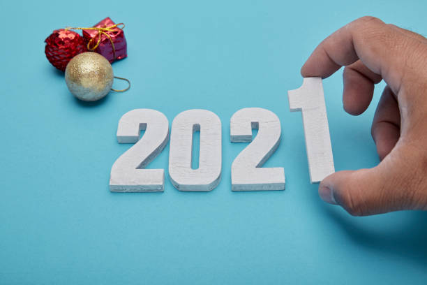 istock Numbers 2021 and hand on pastel blue  background 1270719769