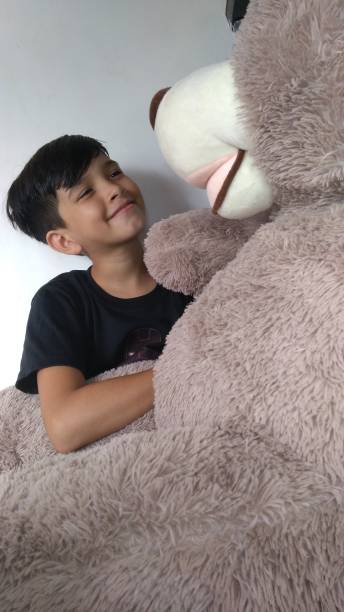 istock Teddy Time.  A Playful Young Boy Plays with his Huge Teddy Bear! 1270724478