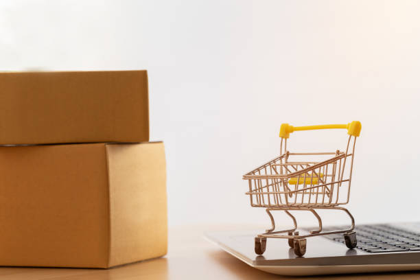 istock Shopping cart or trolley on a notebook computer placed the side the parcel box for delivery to customers. Commercial transactions conducted electronically on the Internet for distance selling. 1270726078