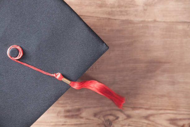 istock Graduation Cap on the wooden desk. Education 1270732435