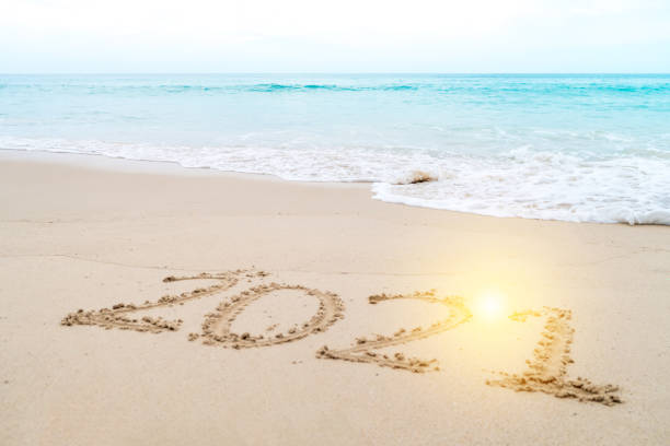 istock 2021 year hand drawn on sand summer beach background. 1270732610