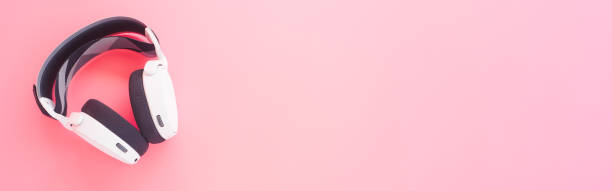 istock White music headphones on pink background. web banner size. 1270734376