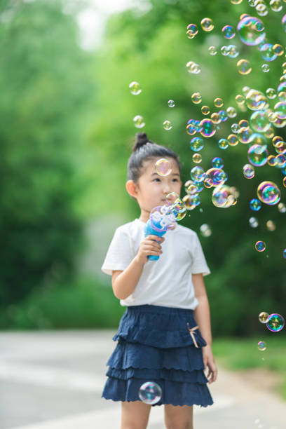 istock Little girl playing blowing bubbles 1270735007