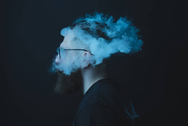 Concept. Smoke enveloped the head man. Portrait of a Bearded, stylish man with smoke. Secondhand smoke. Concept. Smoke enveloped the head man. Portrait of a Bearded, stylish man with smoke. man cigar stock pictures, royalty-free photos & images