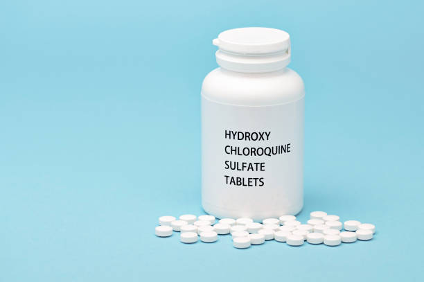 istock HYDROXYCHLOROQUINE in white bottle packaging with scattered pills. Isolated on blue background. Treatments for Coronavirus (COVID-19) 1270738339