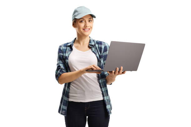ラップトップコンピュータを持ち、カメラを見ている帽子と市松模様のシャツを着た若い女性 - women studio shot jeans young adult ストックフォトと画像