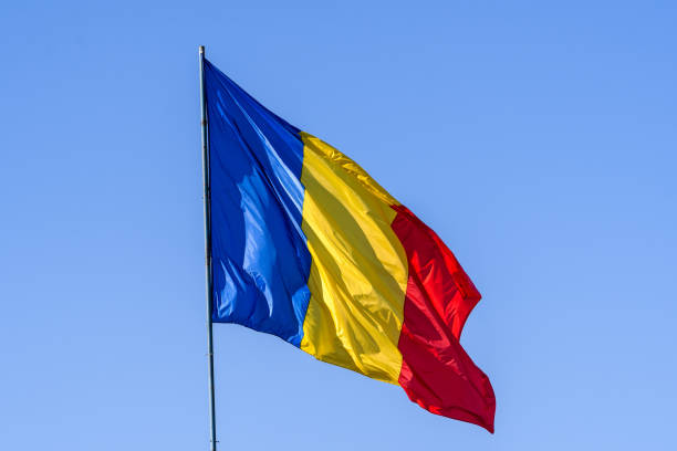 istock Romanian national flag blowing in the wind in direct sunlight towards clear blue sky 1270742284