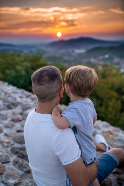 Father and his little son watching the sunset