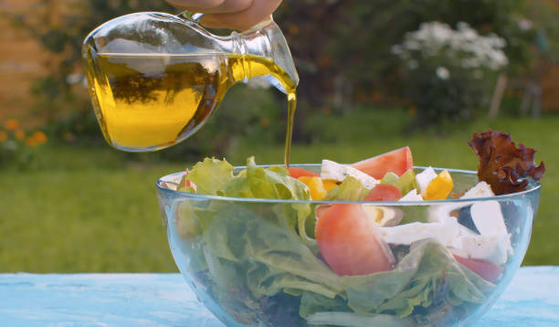 istock Olive oil pouring into bowl with salad 1270743783