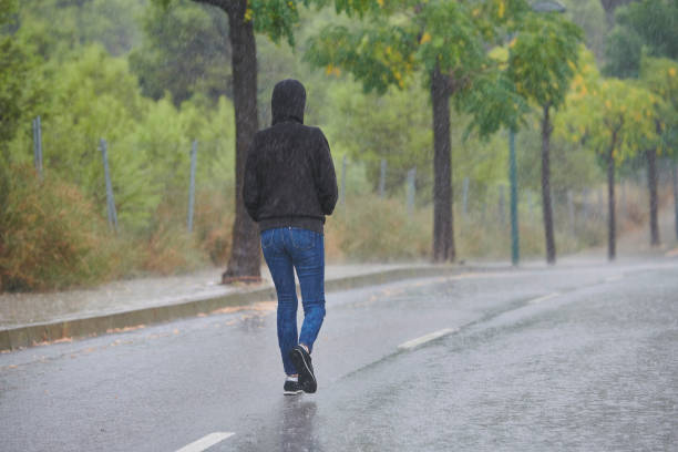 istock woman walking in heavy rain 1270744004