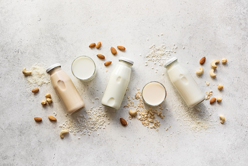 Vegan plant based milk and ingredients, top view, copy space. Various dairy free, lactose free nut and grains milk, substitute drink, healthy eating.
