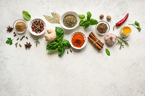 Various Spices, Herbs and Condiments on white stone table, top view, copy space. Healthy cooking, indian food background.