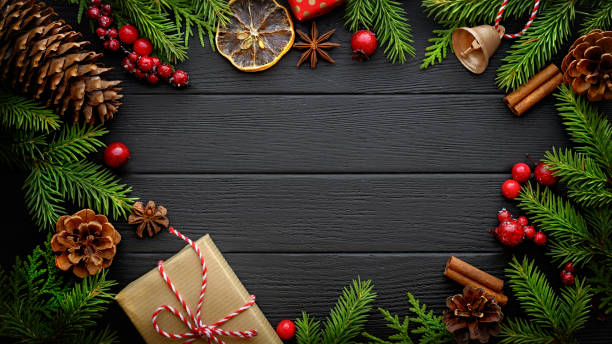 istock Fir tree branches and christmas decorations on black wooden background with copy space 1270749674