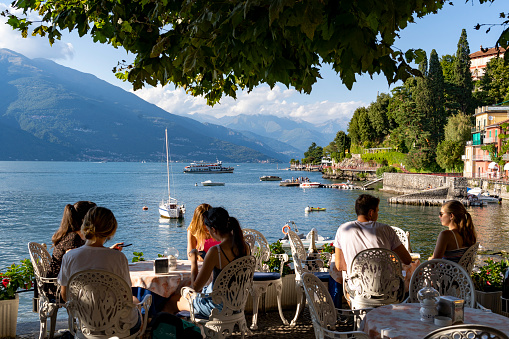 Italy. Lombardy. Lake Como. The colorful village of Varenne. Tourists by the lake