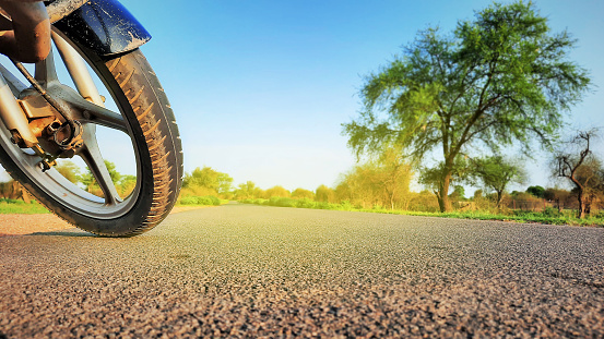 A motorcycle standing on road front tyre closeup