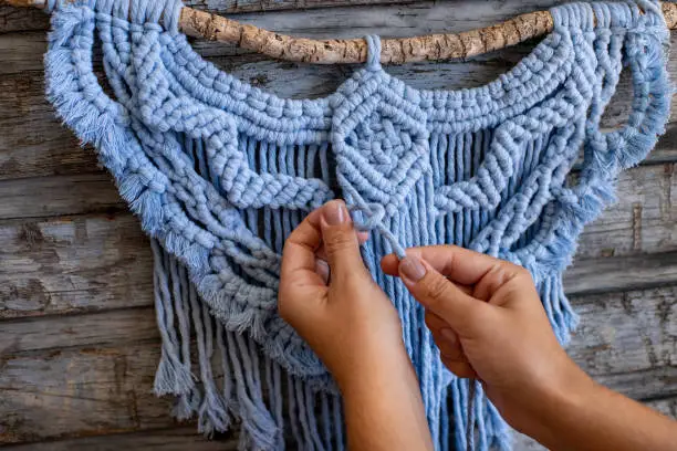 Photo of Weaving macrame at home.