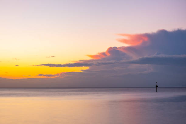istock Nothing but skies and silky smooth water at glowing ocean sunset with copy space 1270758224