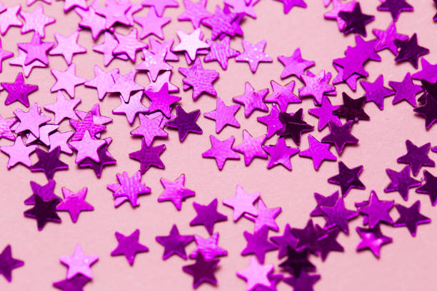 Closeup asterisks sprinkled on a pink isolated background. View from above