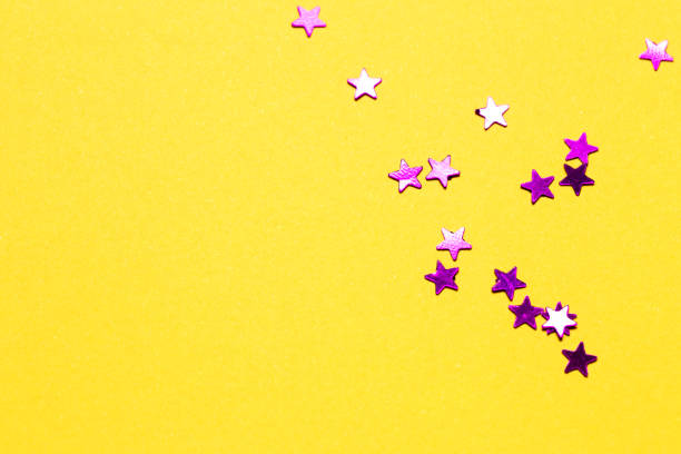 istock Closeup asterisks sprinkled on a yellow isolated background. View from above 1270759668