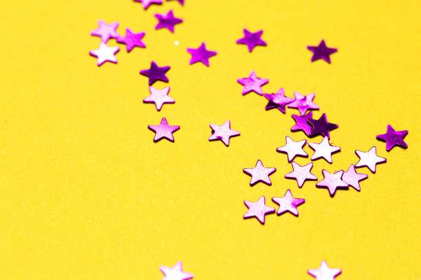 istock Closeup asterisks sprinkled on a yellow isolated background. View from above 1270759675