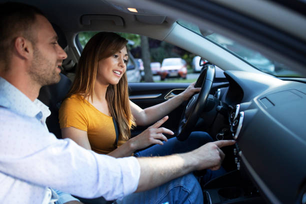 istock Driving instructor showing vehicle dashboard and buttons to the student taking driving lessons. 1270761482