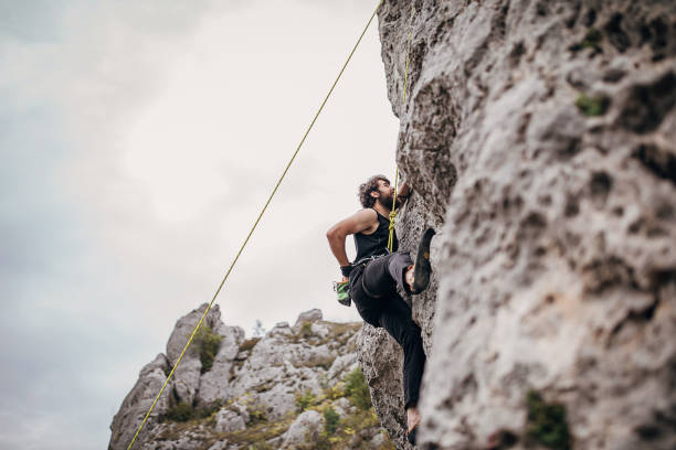 istock Man climbing on rock in nature alone 1270764173