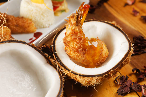 istock Breaded shrimp with Coconut shell in Jamaican sauce, accompanied by steamed rice and garnished with pumpkin and carrot vegetables. 1270765178