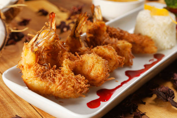 istock Breaded shrimp with Coconut shell in Jamaican sauce, accompanied by steamed rice and garnished with pumpkin and carrot vegetables. 1270765183