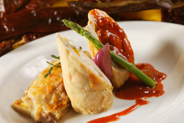 istock Chicken supreme stuffed with cream cheese with corn kernels and crispy mushroom patty seasoned with guajillo chili sauce and asparagus. 1270765648