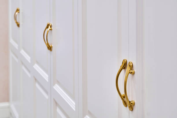 istock Classic white wardrobe with with ornamental golden handles close-up 1270766437