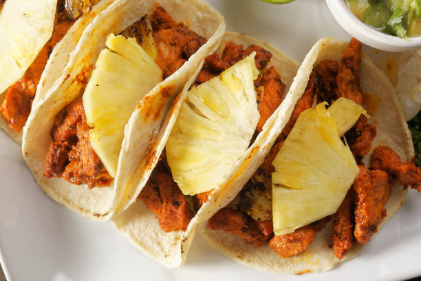 istock Tacos al pastor with guacamole, onion, coriander, pineapple and lemon. 1270768034