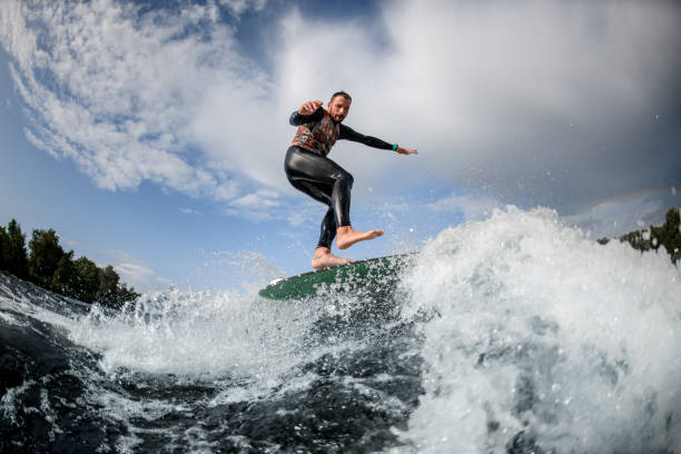 istock Sporty guy having fun rides wave on surfboard 1270769295