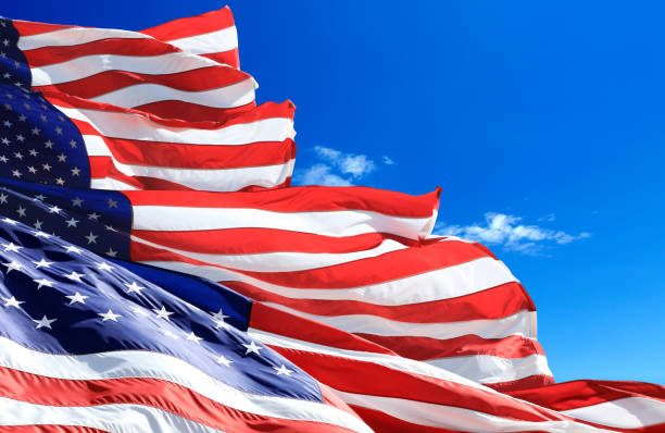 istock Close up group of waving American flags over blue sky 1270773250
