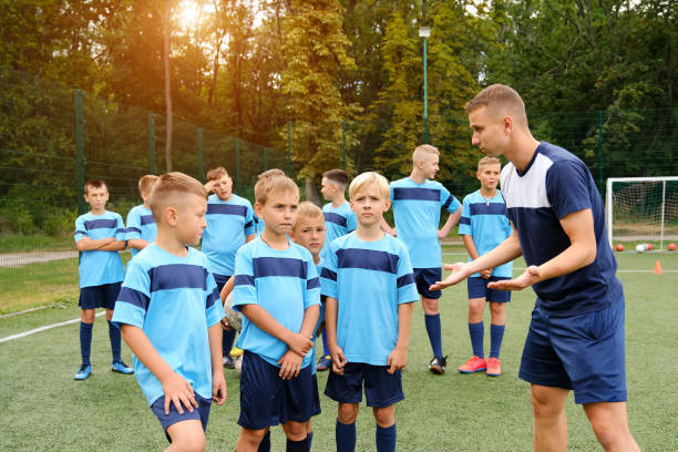 istock Kids in soccer uniforms listen to the coach's explanations during training. 1270773316